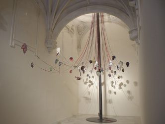 Nancy Spero, Maypole: Take No Prisoners, 2007, Handprinting on aluminum, ribbon, steel chain, and aluminum pole with steel base, Dimensions variable, approximately 30 x 30 x 35 feet Installation view: Capilla de Santa Ana, Centro Andaluz de Arte Contemporáneo, Seville, Spain, 2009, © The Nancy Spero and Leon Golub Foundation for the Arts, Courtesy Galerie Lelong, New York