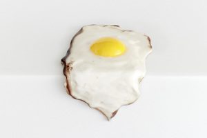 Christopher Chiappa, Single Fried Egg, 2015, Paint, epoxy resin and fiberglass on plaster, dimensions variable. Courtesy: of the artist and Kate Werble Gallery, New York