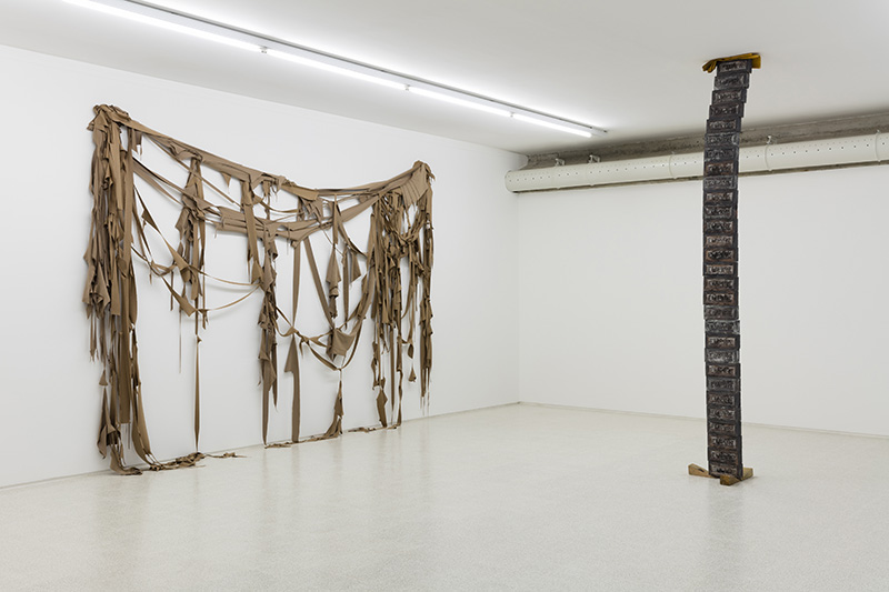 Elisabetta Benassi, Exhibition view at Collezione Maramotti, From the left: 101801, 2017, fabric scraps, 280 x 400 x 20 cm; Infinity, 2017, bronze, wood wedges, gloves, 310 x 40 x 47 cm, © Elisabetta Benassi, Photo: Andrea Rossetti, Courtesy Collezione Maramotti