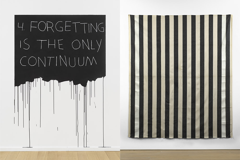 Left: Mel Bochner, Forgetting Is The Only Continuum, 1970 / 2018, Acrylic paint and oil pastel on wall, 180.3 x 121.9 cm,Edition 1 of 3, Courtesy Simon Lee Gallery. Right: Daniel Buren, Peinture acrylique blanche sur tissu rayé blanc et noir (White acrylic paint on striped black and white cotton canvas), 1971, Acrylic on cotton canvas wove in vertical black and white stripes 253 x 215 cm, Courtesy Simon Lee Gallery