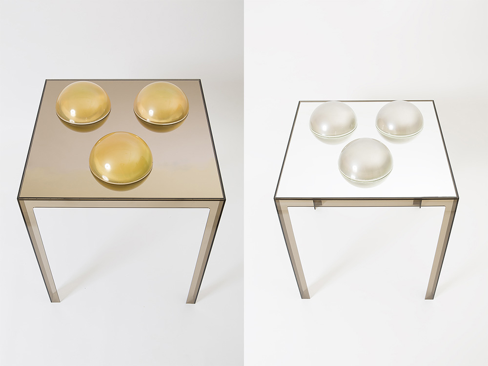 Left : Judy Chicago, Pale Green Domes with Solid Core, 1968, Acrylic paint sprayed on clear acrylic domes, resting on a mirror glass mounted on Parsons acrylic table, 3 domes, 13 x 25 cm in diameter, Courtesy the artist and Salon 94 Gallery-New York. Right: Judy Chicago, Grey Domes with Solid Core, 1971, Acrylic paint sprayed on clear acrylic domes, resting on a mirror glass mounted on Parsons acrylic table, Base 109 x 76 x 76 cm, Courtesy the artist and Salon 94 Gallery-New York