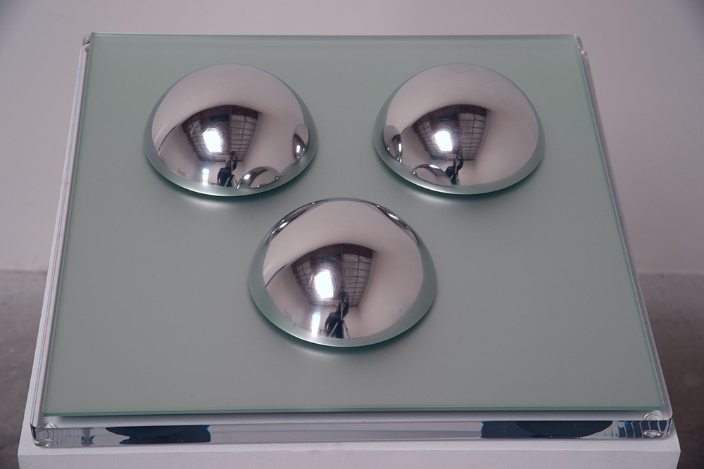 Judy Chicago, Polish Stainless Steel Domes, 1968, Acrylic paint sprayed on clear acrylic domes, resting on a mirror glass mounted on Parsons acrylic table, Base 38,1 x 38,1 x 10,2 cm, 3 domes 5,8x 25,4 cm (diameter), Courtesy the artist and Salon 94 Gallery-New York