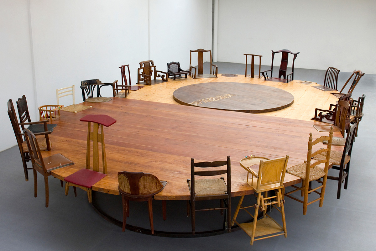 Chen Zhen, Round Table – Side by Side, 1997, Found chairs and wood on metal support Overall: 180 x 630 x 450 cm, © Estate of Chen Zhen/ADAGP, Photo: Galleria Continua