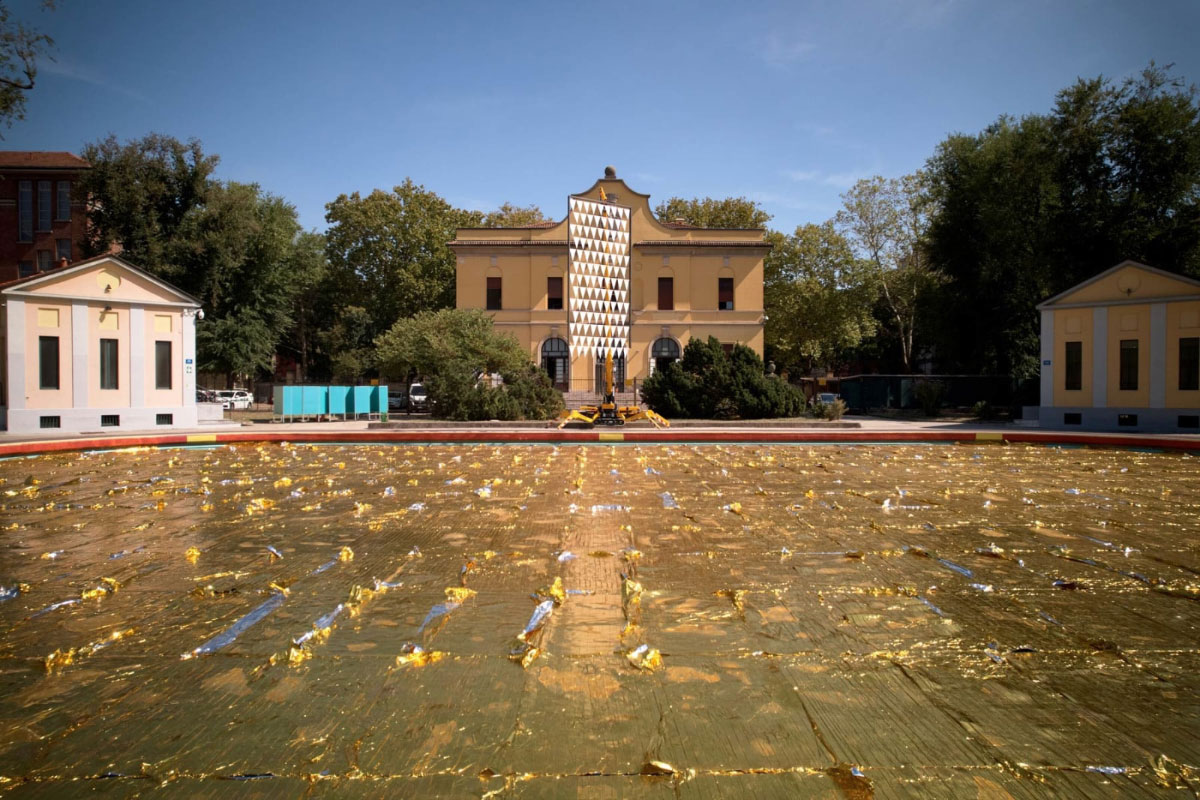 Front: Nari Ward, Emergence Pool, 2022, rescue blankets, eva foam, cable ties, 10.000 x 4.000 cm, Produced by Fondazione Nicola Trussardi, © Nari Ward, Courtesy the artist Back: Nari Ward, Backstroke Flag, 2022, iron, stainless steel, plastic flags, 700 x 300 x 10 cm, Produced by Fondazione Nicola Trussardi, © Nari Ward, Courtesy the artist and Galleria Continua