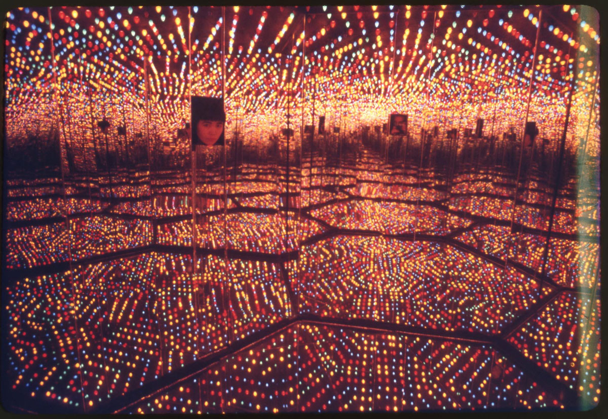Kusama peering into her Infinity Mirrored Room—Love Forever at Richard Castellane Gallery, New York, 1966. © YAYOI KUSAMA. Photograph by Peter Moore. Peter Moore Photography Archive, Charles Deering McCormick Library of Special Collections, Northwestern University Libraries. Photo: © Northwestern University