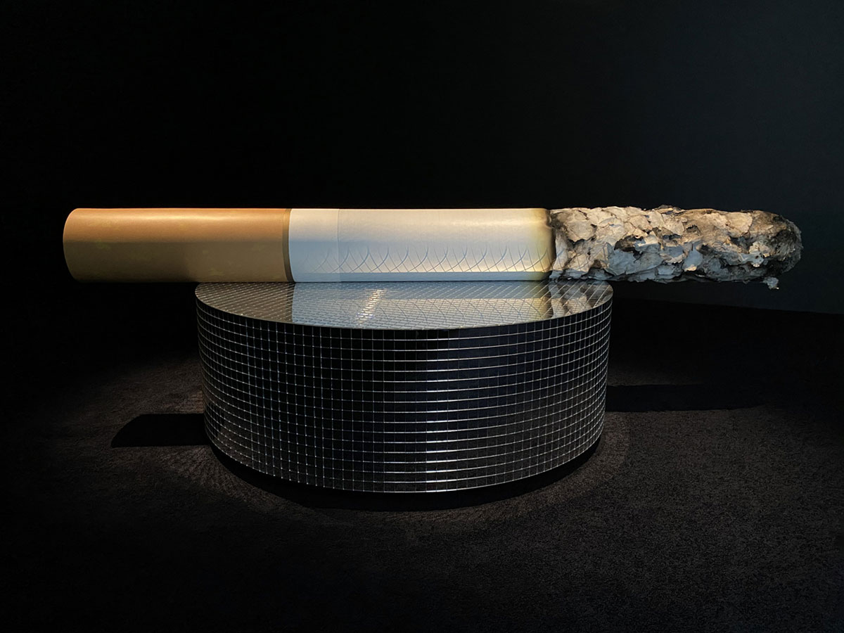 Alex Da Corte, The Fag End 2023, Aluminum, fiberglass, rice paper, foam, ash, glue, Flashe paint, plywood, laser-cut mirrored plexiglass, 27⅜ × 90 × 51 inches; 70 × 229 × 130 cm, © Alex Da Corte, Courtesy the artist and Matthew Marks Gallery