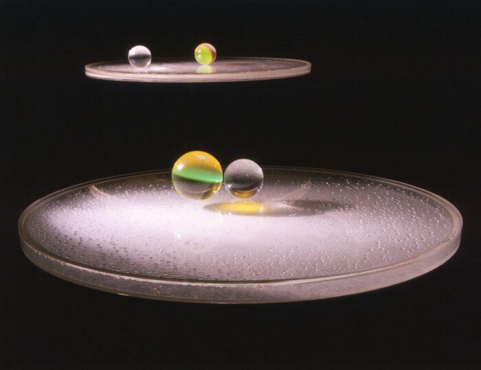 Liliane Lijn, Liquid Reflections/ Series 2 (32"), 1968, Acrylic drum containing water, turntable and projector lamp, acrylic balls, 81,3 cm in diameter, Courtesy Liliane Lijn and Sylvia Kouvali, London / Piraeus, Photo: Stephen Weiss, © Bildrecht, Wien 2024
