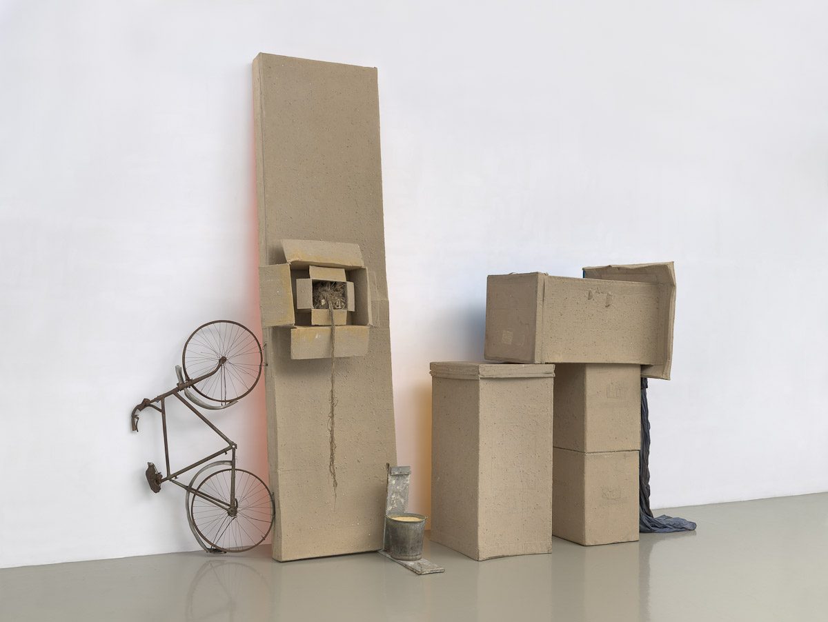 Robert Rauschenberg, Untitled (Early Egyptian), 1973, Sand and acrylic on cardboard with bicycle, fabric, twine, metal bucket, and wood, 153 1/2 x 193 3/8 x 46 1/8 inches (389.9 x 491.2 x 117.2 cm), © Robert Rauschenberg Foundation