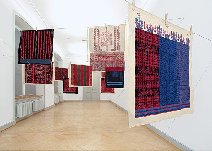 Mona Hatoum (with the women of Inaash), Twelve Windows, 2012–2013, Twelve Palestinian embroideries on fabric, wooden clothespins, and steel cable, Each 100 × 100 cm, overall installation dimensions variable, Installation view at Kunstmuseum St. Gallen, 2013, © Mona Hatoum. Courtesy of Kunstmuseum St. Gallen (photo: Stefan Rohner)