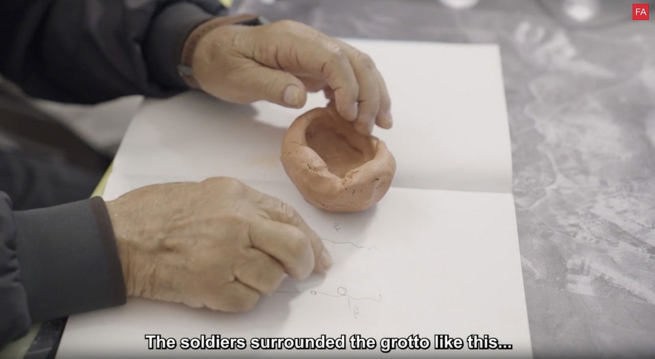Forensic Architecture, Dawayima_2, 2025, ©: Forensic ArchitectureDescription: Nakba survivor Abu Bassam during a ’situated testimony' interview with Forensic Architecture researchers, holding his clay model of Tur al-Zagh cave, the site of one of the major massacres carried out by Israeli forces in the Palestinian village of al-Dawayima on 29 October 1948. From The Massacre at Tur al-Zagh: al-Dawayima, 29 October 1948. 