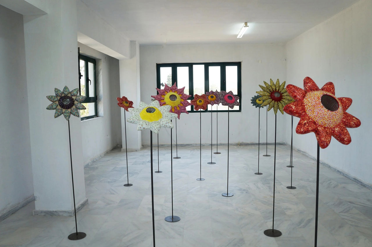 Ioanna Kazaki, Microcosmos–Macrocosmos, 17 Flowers, Polyester, digital images, papier mache, collage, stainless mirror, iron, magnifying lenses, lights. Sound: Stadium Crowd Noise, Dimentions: 150x30x30cm or 165x45x45cm each/ Installation view AcroArt Projects-Thessaloniki, 2026, © & Courtesy the artist