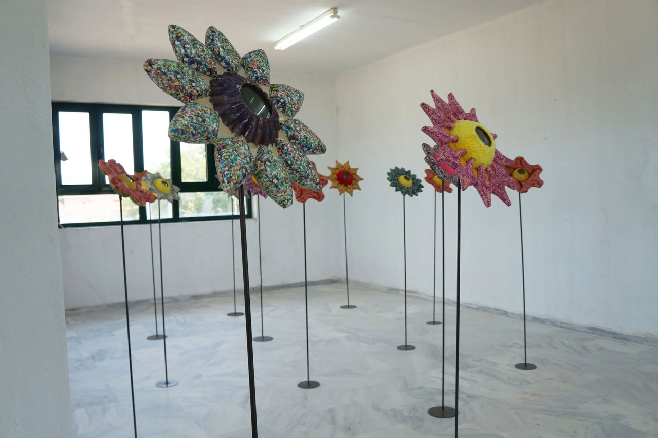 Ioanna Kazaki, Microcosmos–Macrocosmos, 17 Flowers, Polyester, digital images, papier mache, collage, stainless mirror, iron, magnifying lenses, lights. Sound: Stadium Crowd Noise, Dimentions: 150x30x30cm or 165x45x45cm each/ Installation view AcroArt Projects-Thessaloniki, 2026, © & Courtesy the artist
