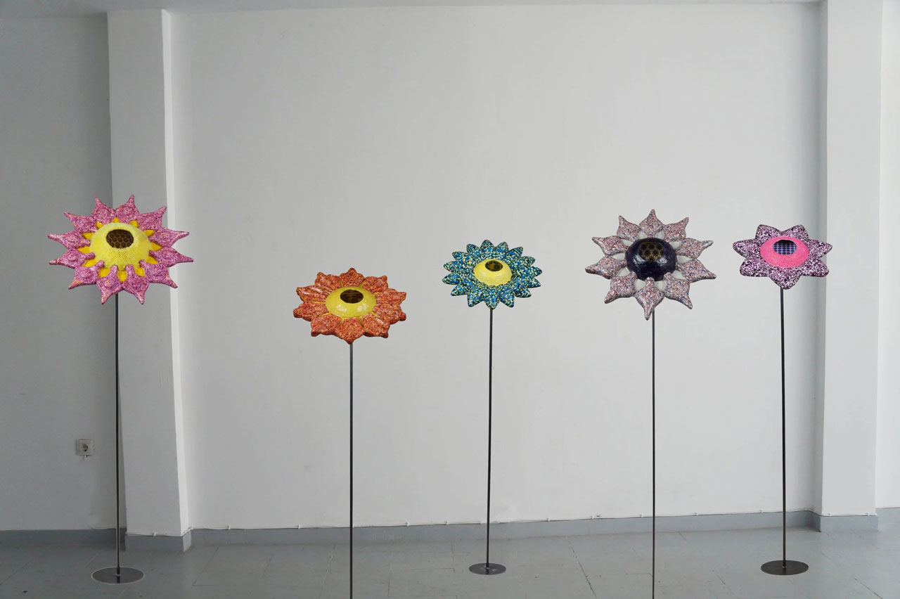 Ioanna Kazaki, Microcosmos–Macrocosmos, 17 Flowers, Polyester, digital images, papier mache, collage, stainless mirror, iron, magnifying lenses, lights. Sound: Stadium Crowd Noise, Dimentions: 150x30x30cm or 165x45x45cm each/ Installation view AcroArt Projects-Thessaloniki, 2026, © & Courtesy the artist