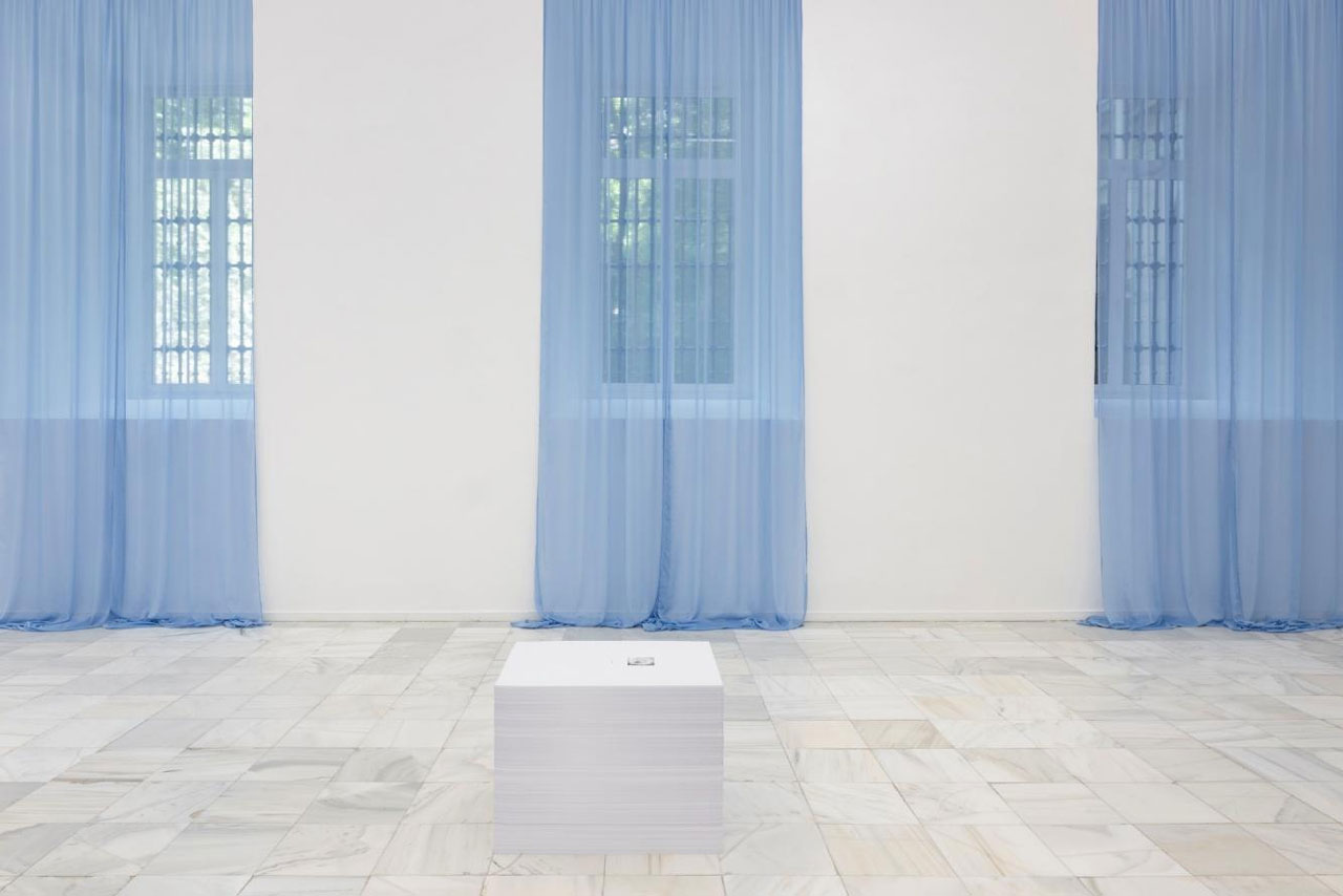 Felix Gonzalez-Torres, “Untitled” (Loverboy), 1989. Sheer blue fabric and hanging device. Dimensions vary with installation and “Untitled” (Beautiful, in conjunction with Lousie Lawler), 1990. Print on paper, endless copies, Installation views of Felix Gonzalez-Torres: Sweet Revenge. Museo Reina Sofía, Madrid, Spain, May 27 – Oct. 12, 2026. Cur. Alejandro Cesarco and Nancy Spector. Photographer: Roberto Ruiz, © Estate Felix Gonzalez-Torres