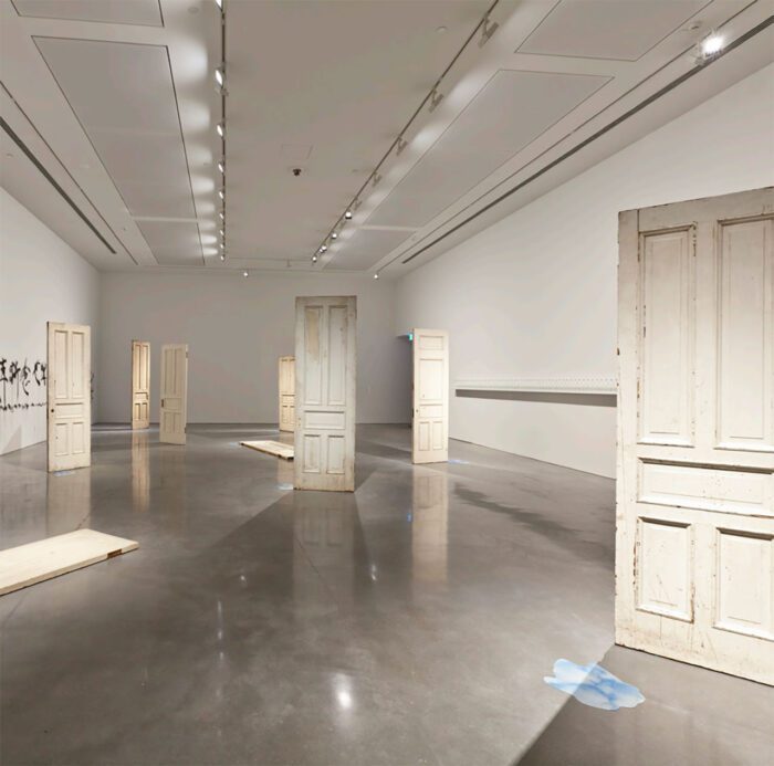 Yoko Ono, DOORS, 2011, Installation, 9 antique wooden doors with artist’s handwritten inscriptions 262 x 84 x 8 cm each, © Yoko Ono, Courtesy the artist and MUSAC (Museo de Arte Contemporaneo de Castilla y Leon)