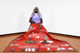 Willie Birch, Memories of the '60s,1992. Painted papier-mâché, canvas, and mixed media, figure: 52 x 25 x 30 in; quilt: 94.5 x 81.5 in, Courtesy Willie Birch Studio; Photo: Sesthasak Booncha