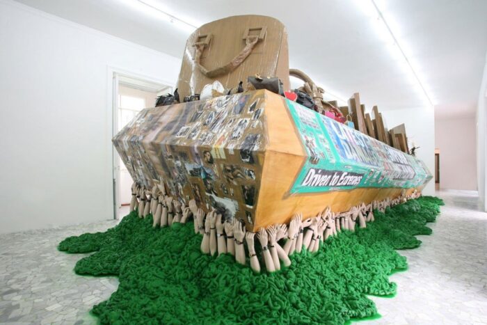 Thomas Hirschhorn, The Green Coffin, 2006, wood, spray paint, polystyrene, hands made of synthetic resin and ceramic, watches, tape, prints, cardboard, fabric, chess, chessboards, crustaceans made of plastic, sculptures, photocopies, handbags, 359 x 112.9 x 436 cm, © Thomas Hirschhorn, Courtesy the artist and Alfonso Artiaco  Gallery