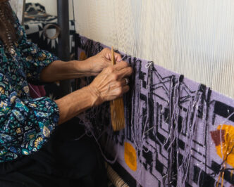 Marilou Schultz weaving Geo XX Diné Computer Chip Weaving, 2026, Photo Credit: Gabby Usinger